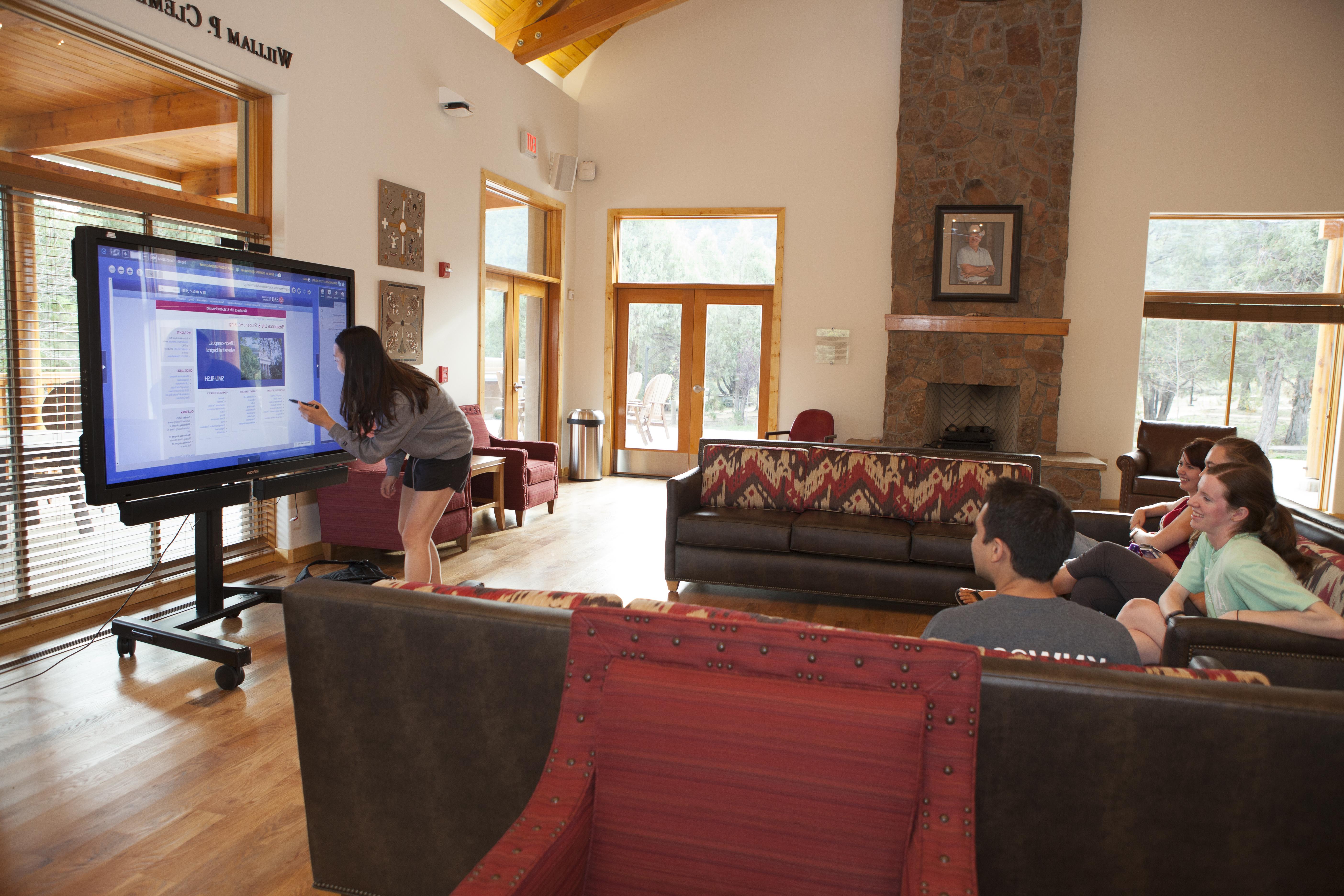 SMU-in-Taos students discuss a project in a common area.