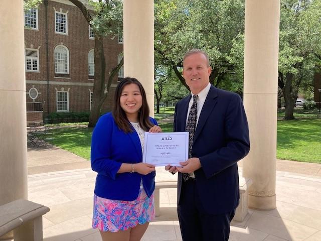 SMU Law Tax Clinic Director Greg Mitchell and 艾米阮 holding a CLEA certificate.